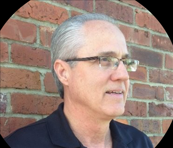 Man in front of brick wall 